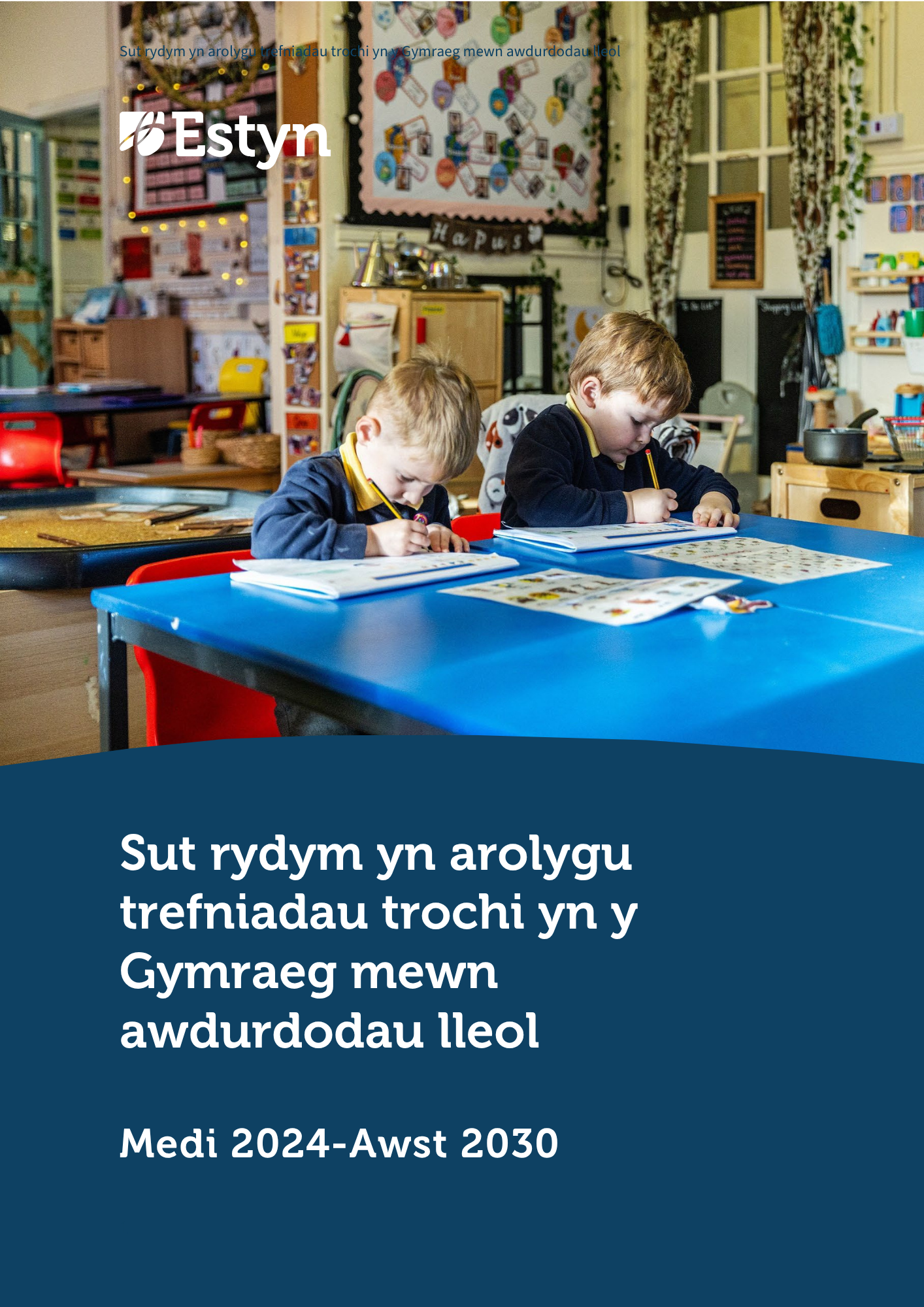 Dau o blant ifanc yn cwblhau gweithgareddau ysgrifennu mewn ystafell ddosbarth.