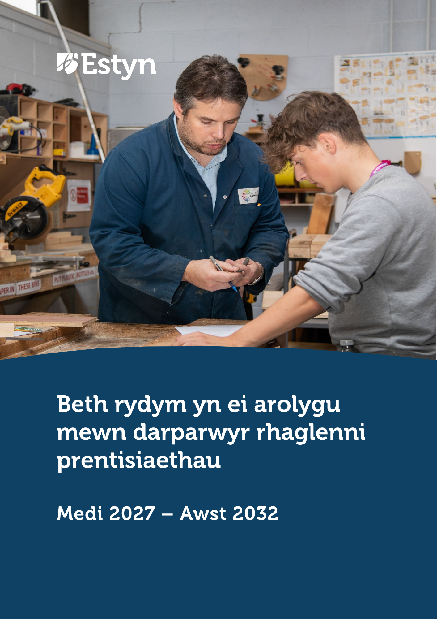 Hyfforddwr a dysgwr yn gweithio gyda’i gilydd mewn gweithdy, yn adolygu mesuriadau a chynlluniau wrth fainc gwaith coed wedi’i hamgylchynu gan offer a deunyddiau.