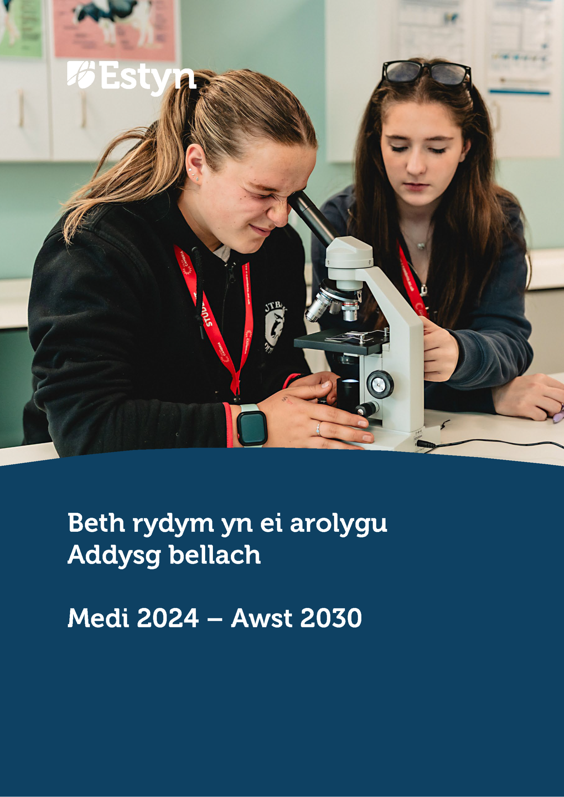 Dau ddysgwr yn defnyddio microsgop yn ystod gwers wyddoniaeth, yn archwilio sbesimen ac yn gweithio gyda’i gilydd mewn labordy ysgol.