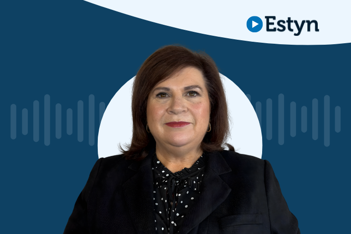 Portread o unigolyn â gwallt brown hyd at yr ysgwyddau, yn gwisgo siaced ddu a blows dotiog, yn sefyll o flaen graffig crwn gyda logo Estyn glas a phatrymau tonnau sain.